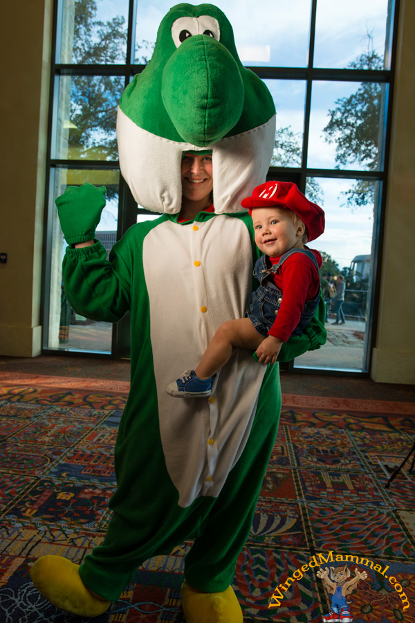 A picture of mommy and baby Yoshi and Mario cosplay at PAX South 2015!